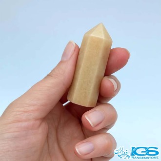 منشور یشم زرد طبیعی در دست برای مدیتیشن و انرژی‌درمانی