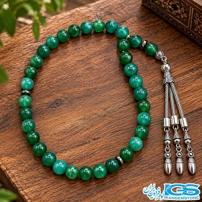 نمای نزدیک مهره‌های تسبیح عقیق سبز ۳۳ دانه‌ای